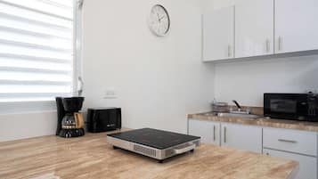 Cafetera o tetera, frigorífico, microondas y placa de cocina