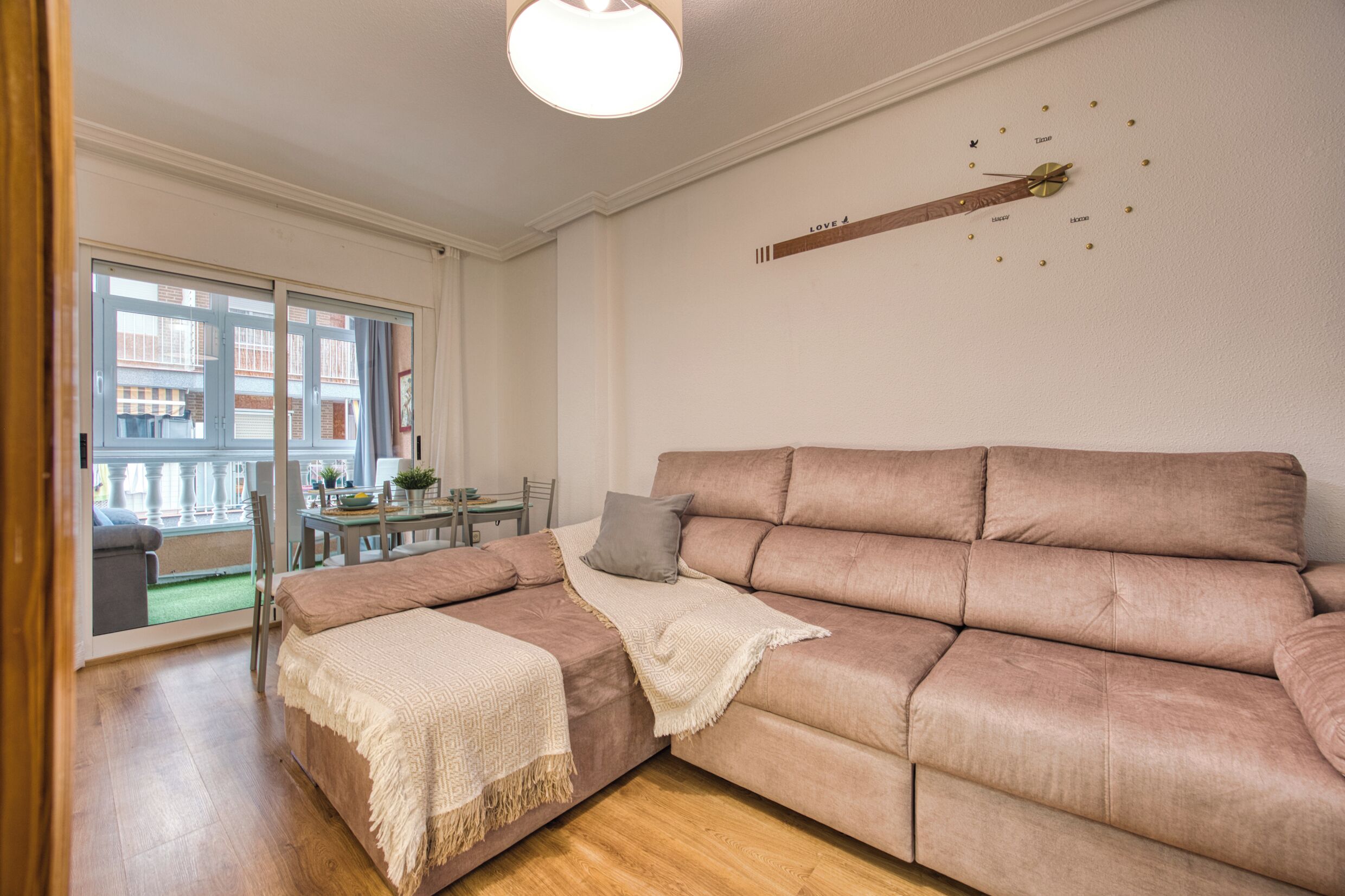 Una sala de estar moderna con un sofá grande, una mesita y vistas al exterior.