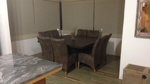 A dining area with a dark wooden table and brown upholstered chairs. - House in the Woods 9 (Valle de Bravo)