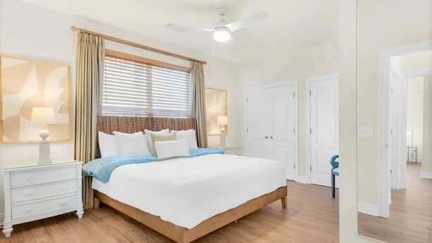 A bedroom with a bed, bedside tables, a ceiling fan, and a window with curtains. - Luxury 6BR, Private Pool, Beach Access, Sleeps 20 (Destin)