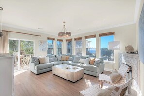 A spacious living room with a large L-shaped sectional sofa, a coffee table, and a fireplace. - Luxury 6BR, Private Pool, Beach Access, Sleeps 20 (Destin)