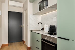 Eine moderne Küche mit Marmorarbeitsplatte, einem eingebauten Backofen und einer Mikrowelle über der Arbeitsfläche.