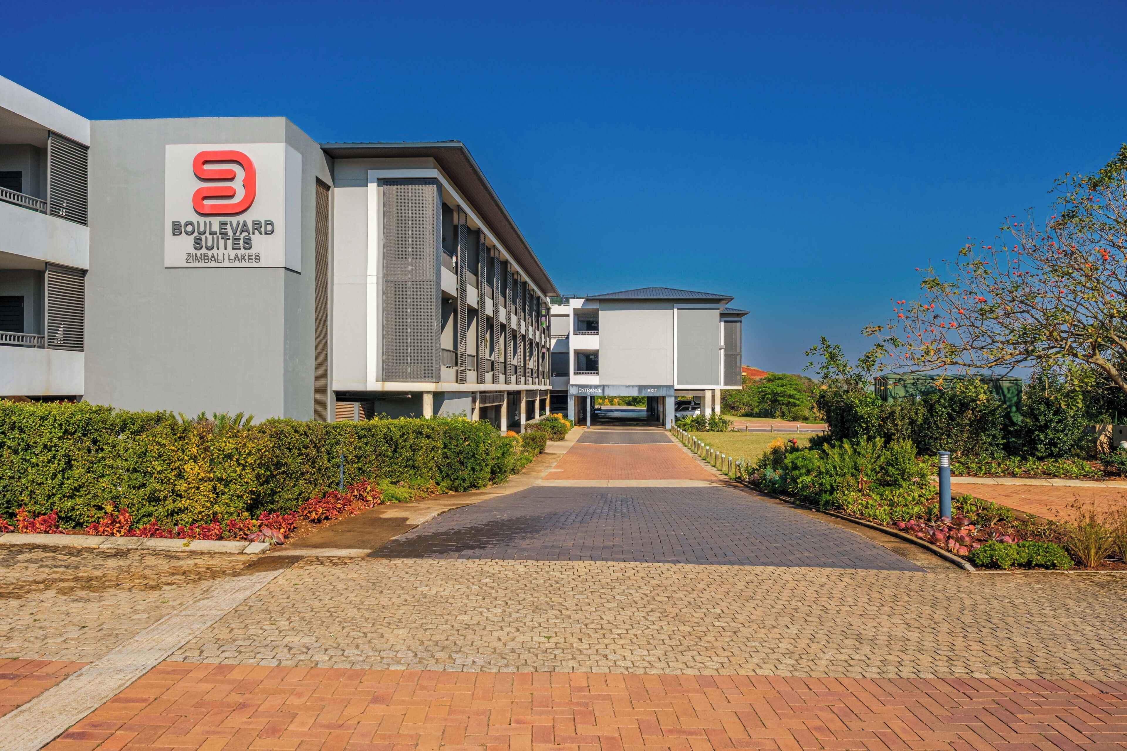 A modern building with a sign for 'Boulevard Suites' and a paved entrance pathway.