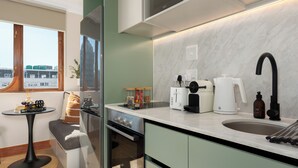 Eine kleine Küche mit Backofen, Kaffeemaschine und Wasserkocher.