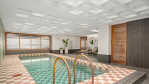 Ein Poolbereich mit Schachbrettfliesen, einer Holzterrasse und einer Decke mit eingelassener Beleuchtung.