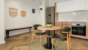 Eine moderne Küche mit einem runden Tisch, zwei Stühlen, einer Bank und einem Bosch-Ofen.