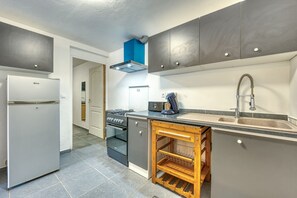 A compact kitchen with a built-in oven, a sink, and a compact refrigerator. - La Case Coco - Bananes - Appartement climatisé (Saint Joseph)