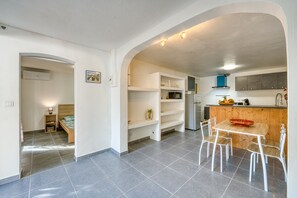 Una cocina compacta con comedor, microondas integrado y refrigerador.
