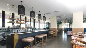 A bar area with stools, a counter, and shelves stocked with bottles. - Effortless Luxury in Rosebank (Johannesburg)