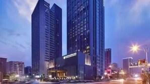 Un immeuble moderne de grande hauteur, doté d’une entrée imposante et de nombreux étages.