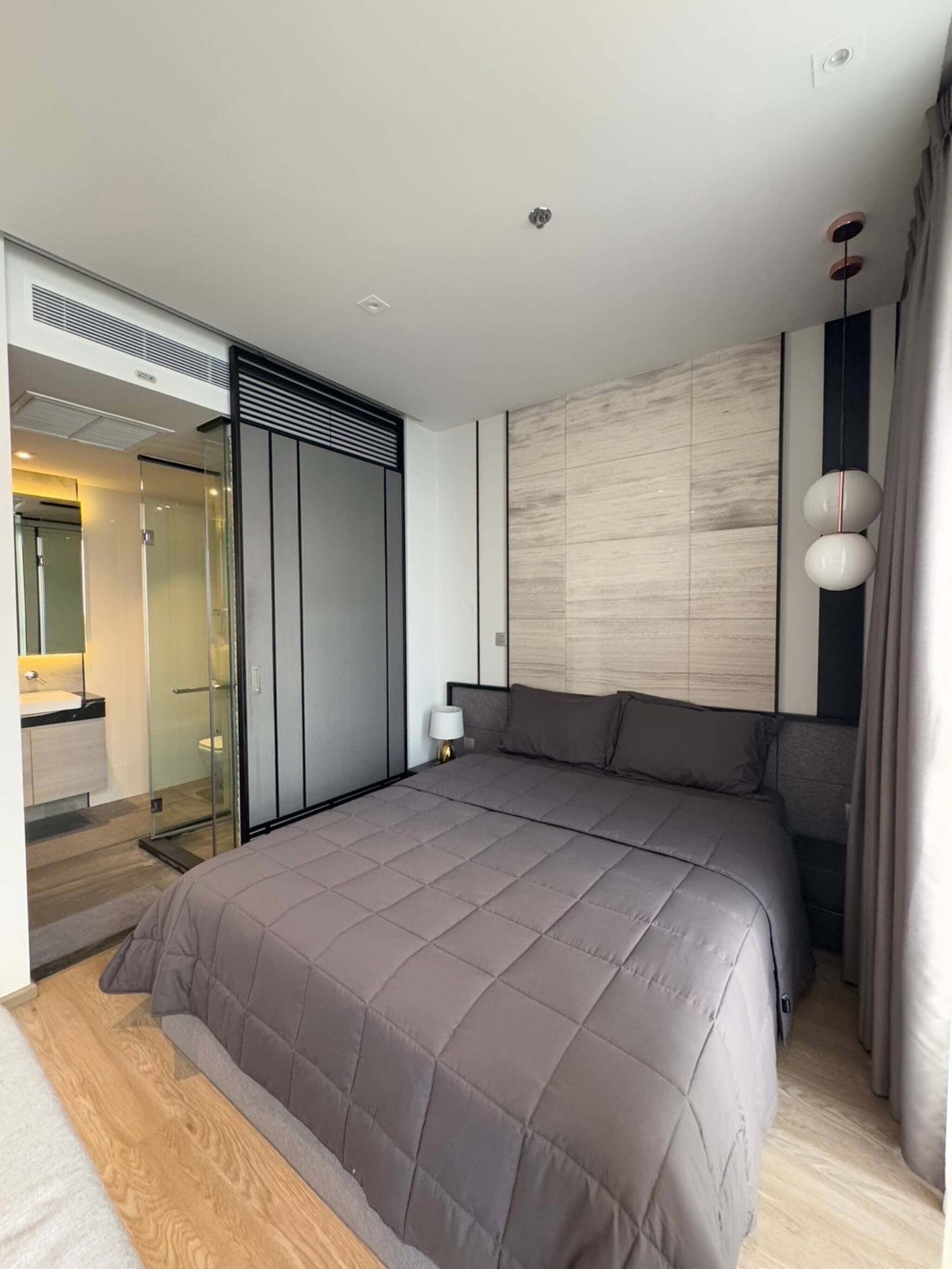 Quarto moderno com cama grande, closet espaçoso e banheiro com box de vidro.
