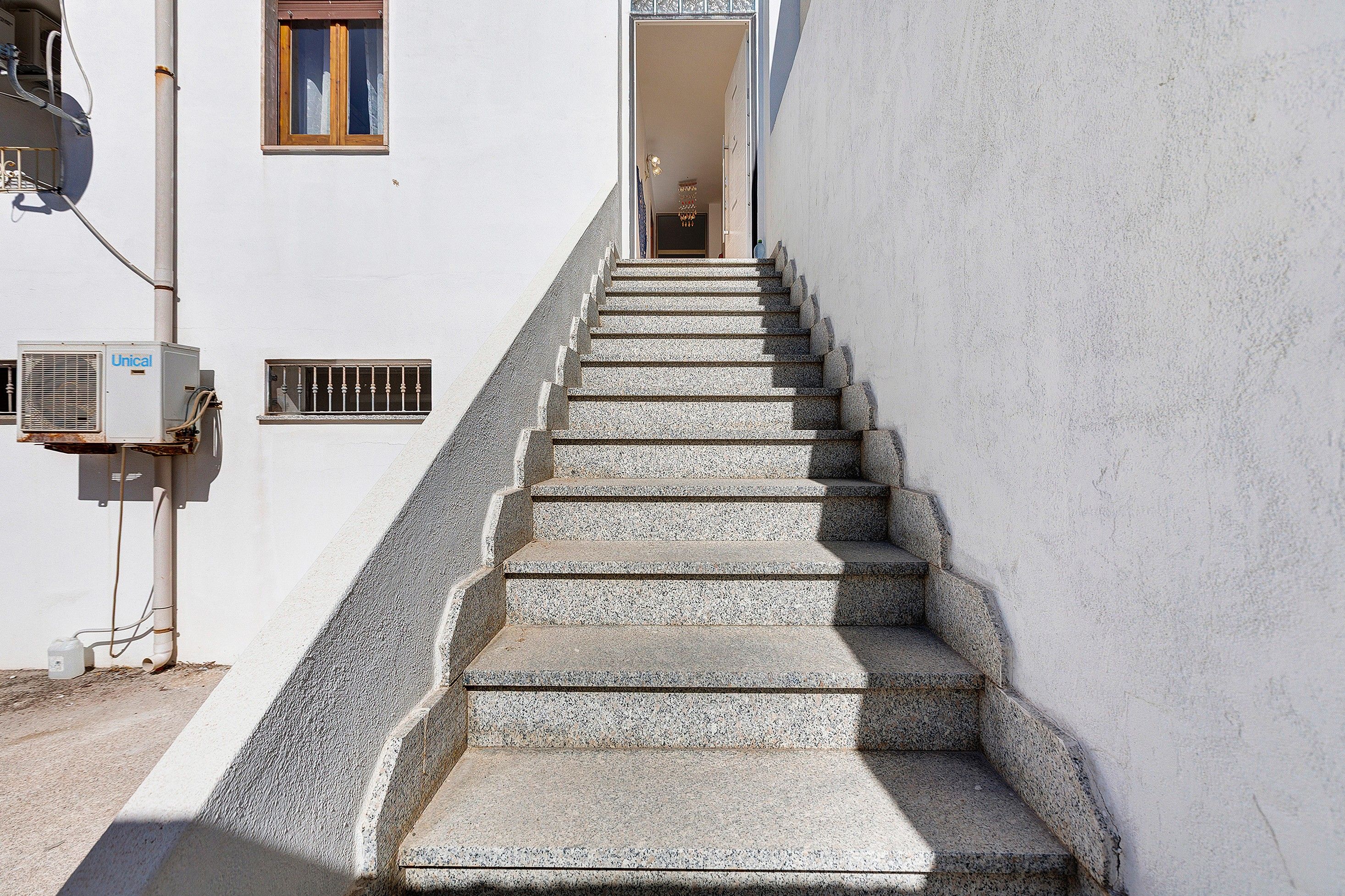 Una scala che porta a una porta con una finestra sopra.