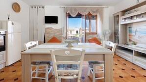 Un comedor con mesa, sillas y vistas al exterior.