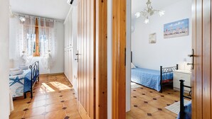 Un dormitorio con cama, mesita de noche y ventana con cortinas.