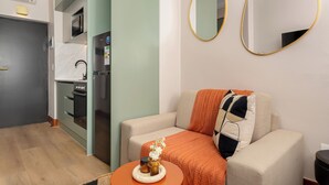 Una sala de estar moderna con un sofá, una mesita con un florero y dos espejos en la pared.