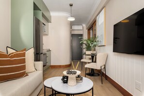 Una sala de estar moderna con un sofá, una mesa de centro y un comedor con una silla y una mesa.