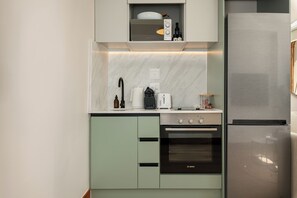 A modern kitchen with a built-in oven, a stainless steel refrigerator, and a microwave. - Charlie and the Chairman | Contemporary Stay (Cape Town)