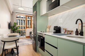 A modern kitchen with a built-in oven, a coffee maker, and a sink. - Charlie and the Chairman | Designer Escape (Cape Town)