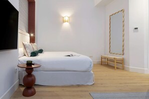 A bedroom with a bed, bedside table, lamp, and a large mirror. - Genteel Home Antonio Marchena 002 (Seville)
