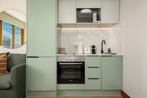 A compact kitchen with a Bosch oven, a microwave, and a coffee maker. - Charlie and the Chairman | Elevated City Stay (Cape Town)