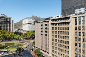A multi-story building with a modern architectural design, featuring a mix of glass and concrete facades. - Charlie and the Chairman | CBD Suite with Balcony (Cape Town)