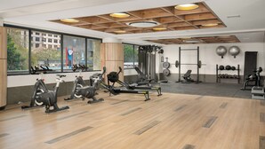 A gym with exercise equipment, large windows, and a view of the outside. - Charlie and the Chairman | Sleek Studio Stay (Cape Town)