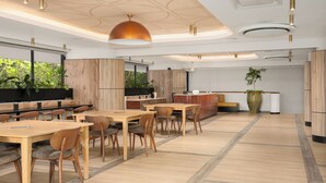 A modern dining area with wooden tables and chairs, a large pendant light, and a view of greenery outside. - Charlie and the Chairman | Sleek Studio Stay (Cape Town)