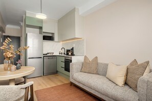 A compact living space with a kitchenette, a dining area, and a sofa. - Charlie and the Chairman | Sleek Studio Stay (Cape Town)