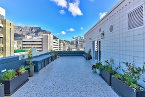 Eine Dachterrasse mit Blick auf eine Berglandschaft und die Stadt.
