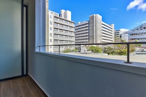 A balcony with a metal railing overlooking a cityscape with modern buildings. - The Carrington | Spacious CBD Apartment (Cape Town)