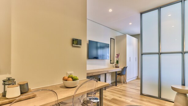 Una cocina moderna con encimera de madera, un cuenco de fruta y una cafetera.