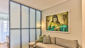 Una sala de estar moderna con un sofá, una mesita auxiliar y un ventanal con persianas.