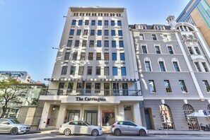 A multi-story building with a prominent entrance labeled 'The Carrington.' - The Carrington | Spacious CBD Apartment (Cape Town)