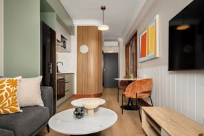 Una sala moderna con sofá, una mesa baja y un comedor con una silla y una mesa.