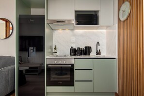 A compact kitchen with a Bosch oven, a microwave, and a coffee maker. - Charlie and the Chairman |Cityscape Stay and Balcony (Cape Town)