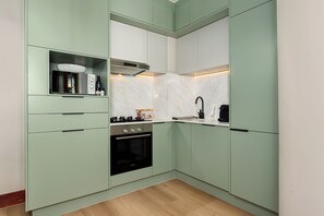 A compact kitchen with a Bosch oven, a built-in microwave, and a coffee maker. - Charlie and the Chairman | Modern CBD Apartment (Cape Town)