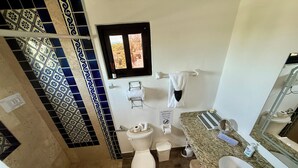 A bathroom with a toilet, sink, and a window. - Cozy 1-bedroom studio in perfect Isla Mujeres with AC (Isla Mujeres)