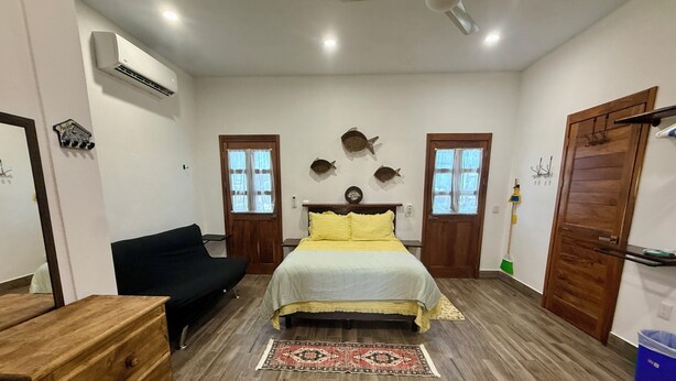 A bedroom with a bed, a dresser, a chair, and a ceiling fan. - Cozy 1-bedroom studio in perfect Isla Mujeres with AC (Isla Mujeres)