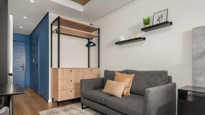 Un salon moderne avec un canapé gris, un meuble en bois et une porte bleue.