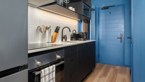 Une cuisine moderne équipée d’un four encastré, d’un évier et d’une machine à café.