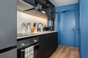 Eine moderne Küche mit Backofen, Spüle und Kaffeemaschine.