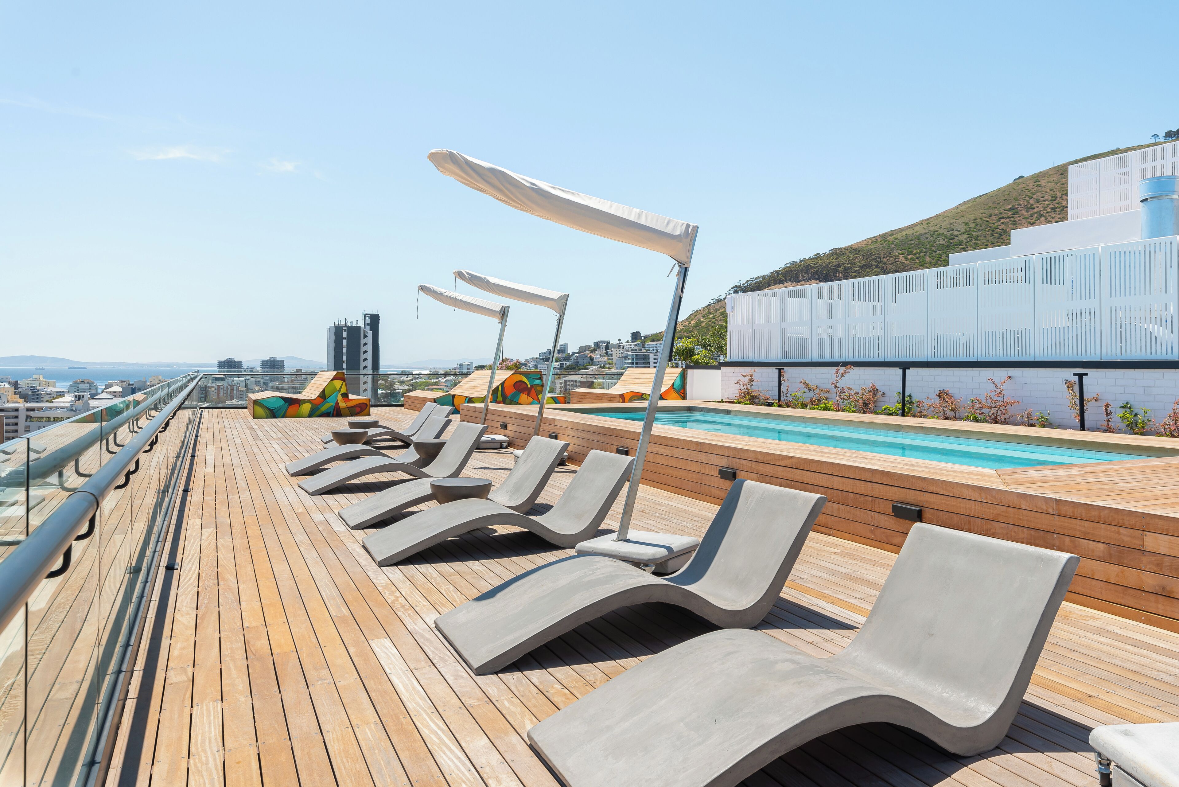 A sun deck with lounge chairs and a pool.
