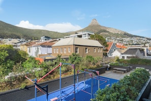 Zona residencial con vista a una montaña y un parque infantil con equipo de ejercicio.