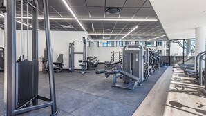 A gym with various exercise equipment, including treadmills and weight machines. - One Rosebank | Elevated Urban Comfort (Johannesburg)