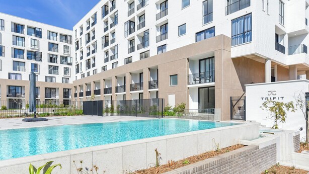 A modern building with a swimming pool, multiple balconies, and a gated entrance. - One Rosebank | Elevated Urban Comfort (Johannesburg)