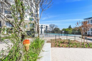 A modern building with a swimming pool, surrounded by trees and a well-maintained garden. - One Rosebank | Elevated Urban Comfort (Johannesburg)