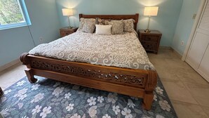 A bedroom with a large bed, two bedside tables, and a window.