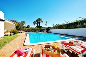 A swimming pool with lounge chairs and a dining setup. - Villa with Pool and BBQ near Galé Beach (Albufeira)
