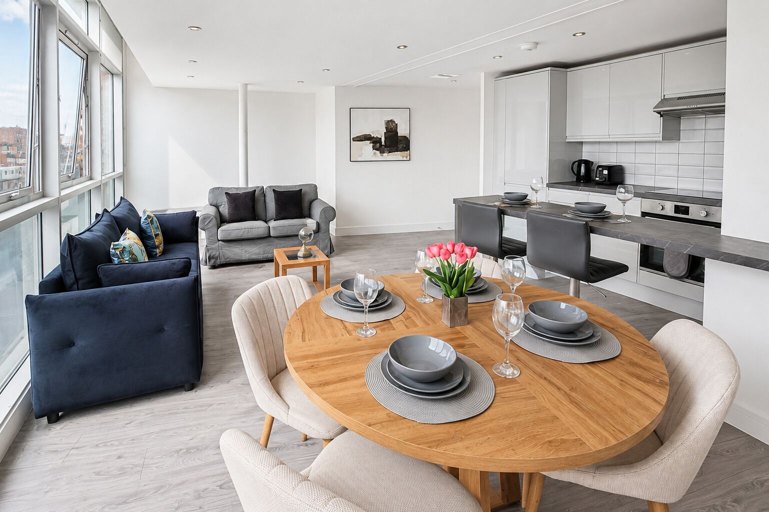 Un appartement moderne comprenant un coin repas, une cuisine et un espace salon.
