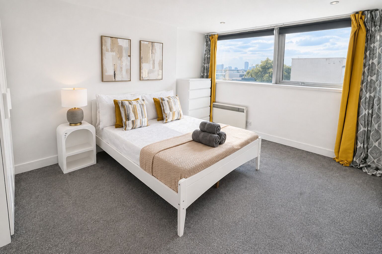 A bedroom with a bed, bedside tables, a lamp, a radiator, and a window with curtains.